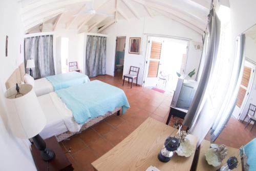 a bedroom with a bed and a table and a tv at Country Side Cottages in Oracabessa