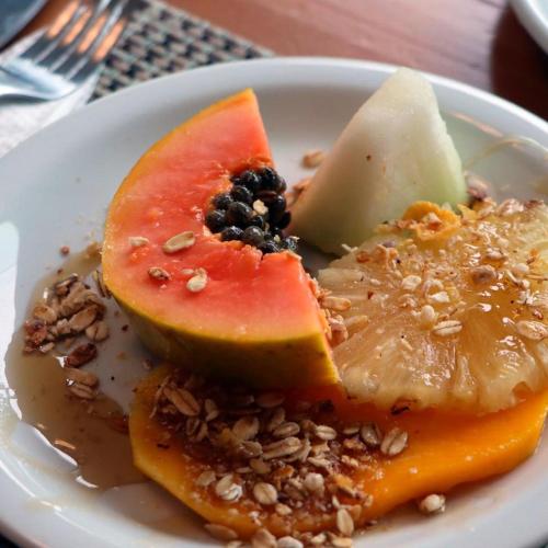 a plate of food with fruit and nuts on a table at Hotel Bertell in Penedo