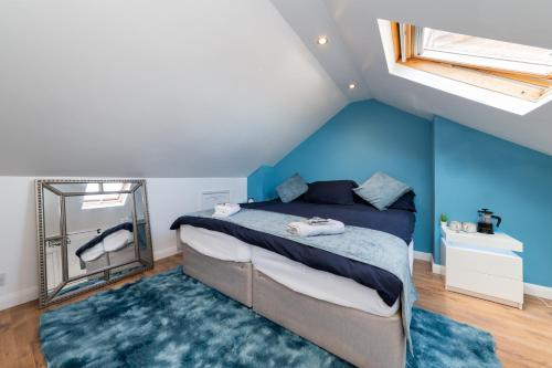 a bedroom with blue walls and a bed with a mirror at Favourite by couple and group of 3 Cosy Apartment Close to City Centre in Reading