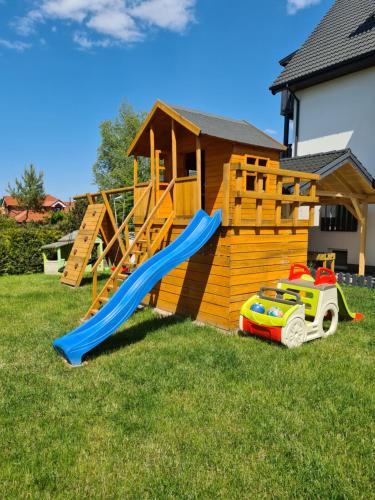 a playground with a slide and a toy car in the grass at Willa Plażowa in Mielenko