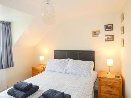 1 dormitorio con 1 cama con 2 toallas en Drosgl, en Llangefni