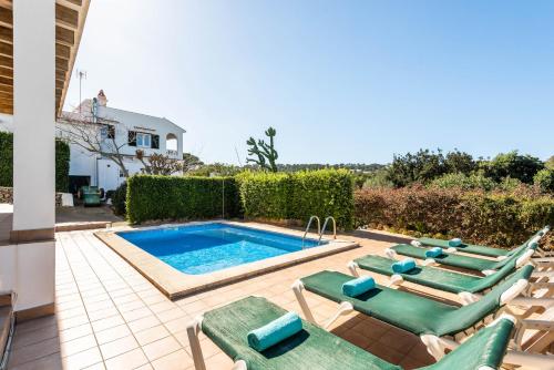 a swimming pool with chaise lounge chairs and a swimming pool at Villa Sa Oreneta - Port de Addaia in Port d'Addaia
