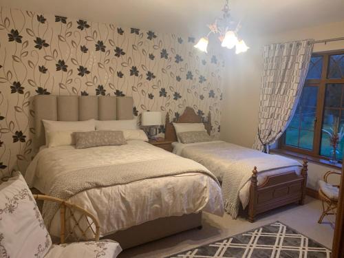 a bedroom with two beds and a window at Mayrone House B&B in Donegal