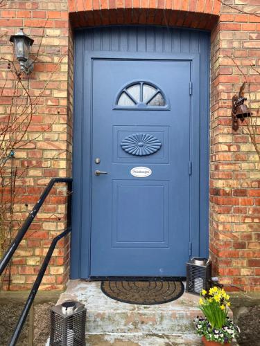 a blue door in a brick building with a window at Windalens på Österlen in Tomelilla
