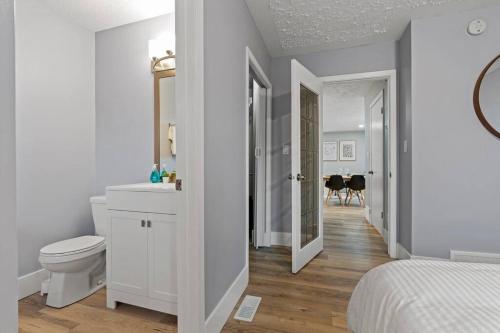 a white bathroom with a toilet and a sink at Elegant Boho Retreat - 8 min to WEM in Edmonton