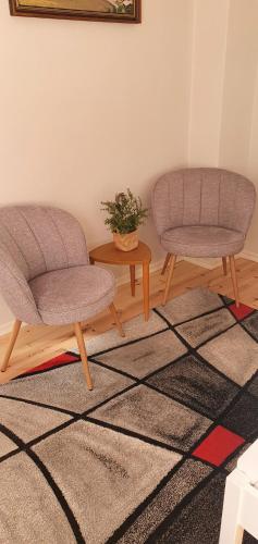 two chairs and a table in a room at Windalens på Österlen in Tomelilla