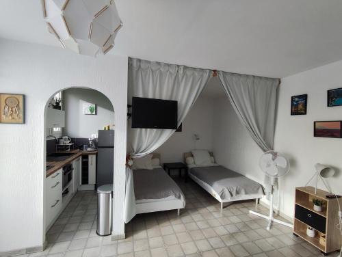 um quarto com uma cama e uma secretária com um espelho em studio meublé classé 2 étoiles - 30m² em Gréoux-les-Bains