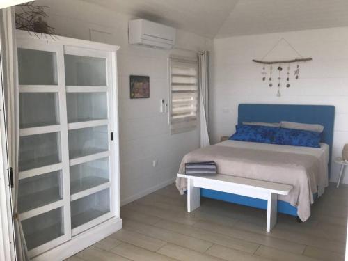 Un dormitorio con una cama con almohadas azules y una mesa. en Pkbleucoco, en Opoa