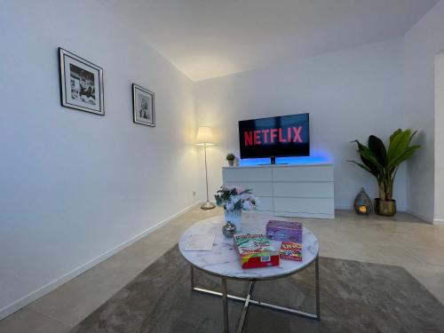 uma sala de estar com uma mesa e uma televisão em Stilvolle 52qm Wohnung in attraktiver Lage em Essen