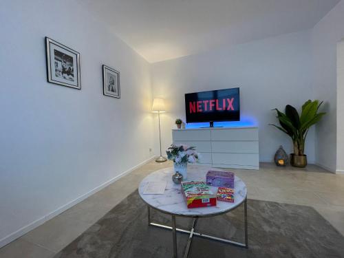 a living room with a table and a tv at Stilvolle 52qm Wohnung in attraktiver Lage in Essen