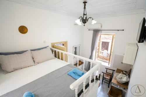 Un dormitorio con una cama blanca y una ventana. en Mansion House(est.c1890)-Daedalus, en Halki