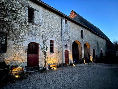 an old stone building with two doors and lights in front at Le Manoir des Doyens Loft - Sleeps 8 - Breakfast Included! in Bayeux