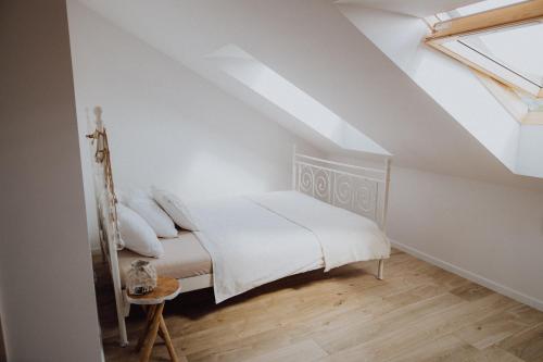a bedroom with a white bed in a attic at Dom na łące in Lubawka