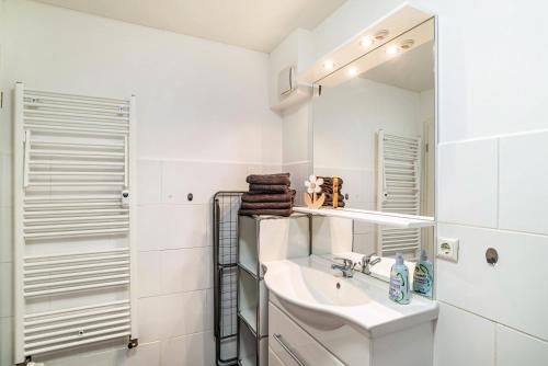a white bathroom with a sink and a mirror at Vogtshaus in Gernsbach