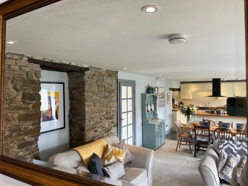 a living room with a couch and a stone wall at Spacious 4 Bedroom Farmhouse in Pembrokeshire