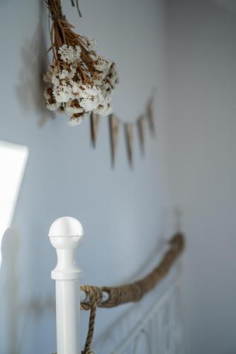 a bouquet of flowers on a white wall with a candle at Dom na łące in Lubawka