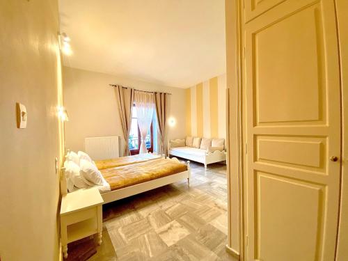 een slaapkamer met een bed, een bank en een deur bij Hermes Hotel in Mithimna