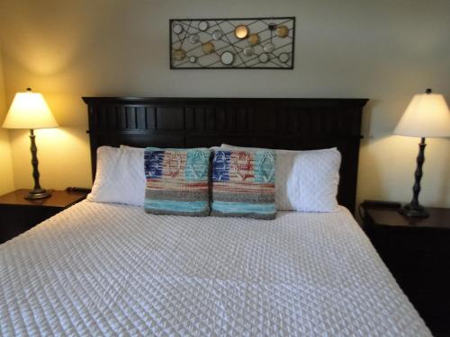 a bedroom with a bed with pillows and two lamps at River Crossing Resort in Pigeon Forge