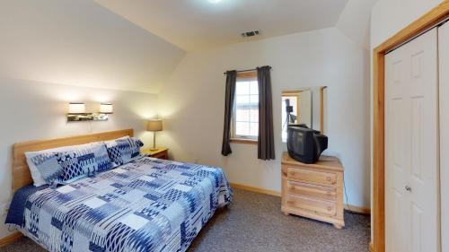 a bedroom with a bed and a tv on a dresser at Wiggins River Retreat 5 On The River in Red River