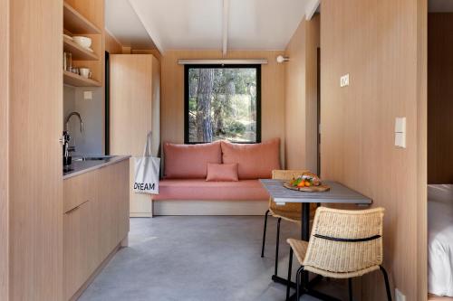 a small kitchen with a pink couch and a table at Wecamp San Sebastián in San Sebastián