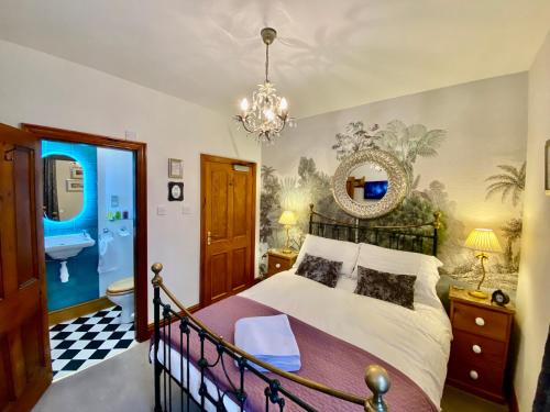 a bedroom with a large bed and a chandelier at Elm Tree Lodge in Keswick