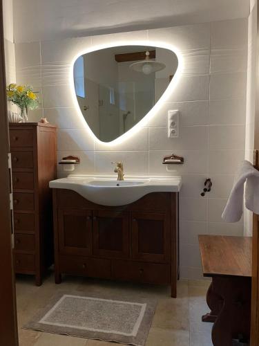 a bathroom with a sink and a large mirror at Kis-Duna Vendégház in Dunabogdány