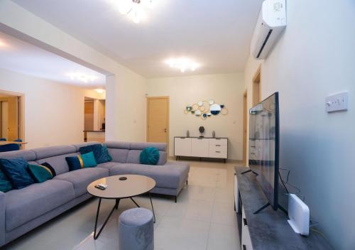 a living room with a couch and a table at Bay View Gardens by TrulyCyprus in Limassol