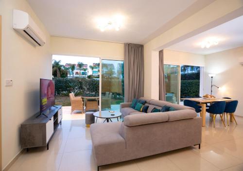 a living room with a couch and a tv at Bay View Gardens by TrulyCyprus in Limassol