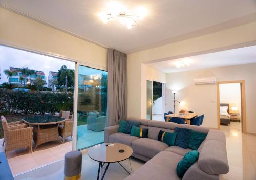 a living room with a couch and a table at Bay View Gardens by TrulyCyprus in Limassol