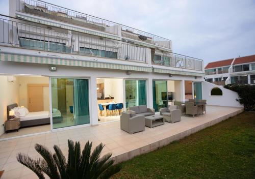 a large building with a patio with chairs and tables at Bay View Gardens by TrulyCyprus in Limassol