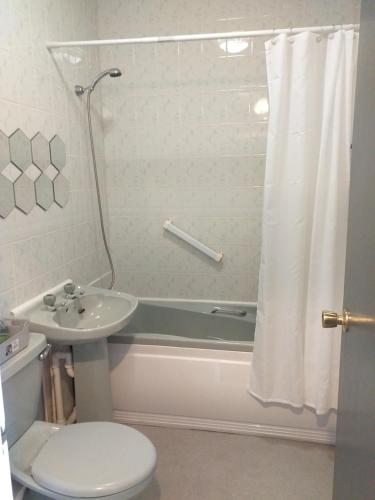 een badkamer met een wastafel, een toilet en een bad bij Cricket Stadium View in Scarborough