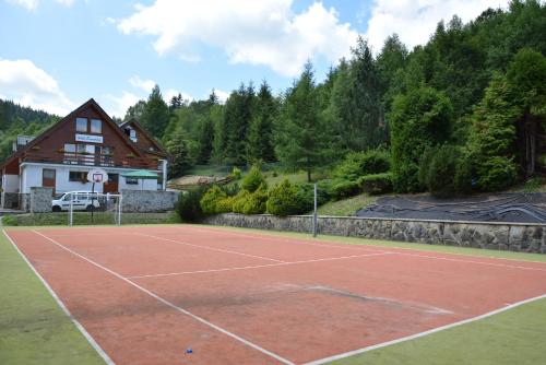 a tennis court in front of a house at Hotel SEVERKA in Zákopčie