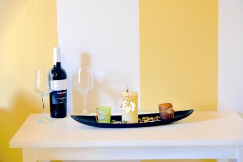een tafel met een fles wijn en twee wijnglazen bij Hermes Hotel in Mithimna