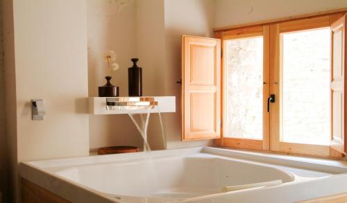 eine große weiße Badewanne in einem Zimmer mit Fenster in der Unterkunft Clauhomes Casa Rural Deluxe in Tarrés