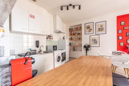 une cuisine avec des armoires blanches et une table en bois dans l'établissement F2 COURT METRAGE CENTRE VILLE CLERMONT-FD, à Clermont-Ferrand