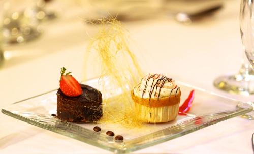 un plato con un pastel de chocolate y una fresa en él en Park Hotel Calama, en Calama