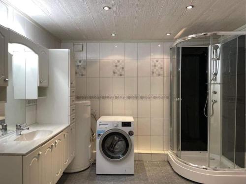 a bathroom with a washing machine and a sink at Sentral og koselig leilighet in Tromsø