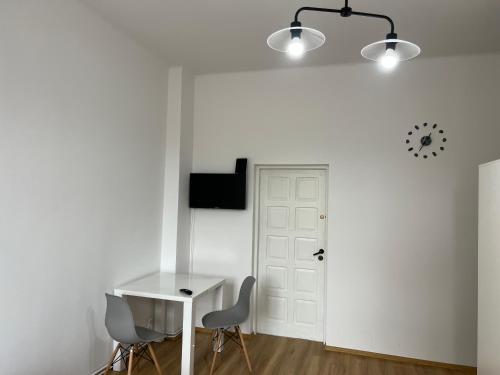 une chambre blanche avec une table et deux chaises dans l'établissement Apartament Chrobrego 30/3, à Zielona Góra