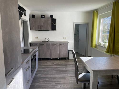 a kitchen with a table and a dining room at Auf dem Land und doch ganz nah (EG) in Krölpa