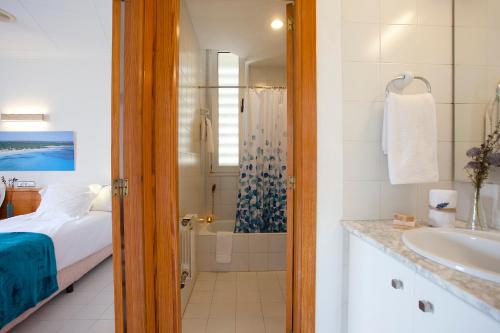 uma casa de banho com uma cama, um chuveiro e um lavatório. em Apartamento Es Trenc 1 em Colonia Sant Jordi