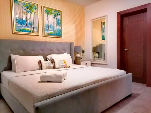 a large bedroom with a large bed with two pictures on the wall at Suites Room Soha II in Santiago de los Caballeros