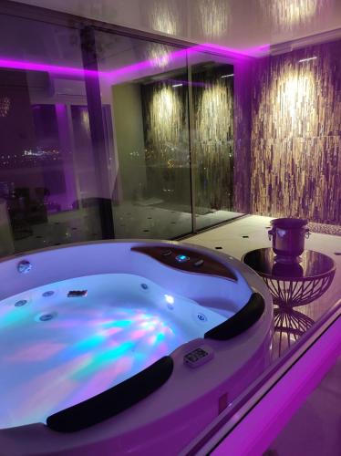a bath tub in a room with purple lighting at Premium Sky Jacuzzi Apartment in Klaipėda