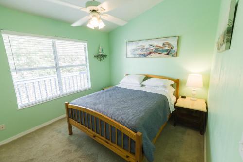 um quarto com uma cama, uma ventoinha de tecto e uma janela em Five Bedroom Home in the Heart of St Aug Beach em Saint Augustine