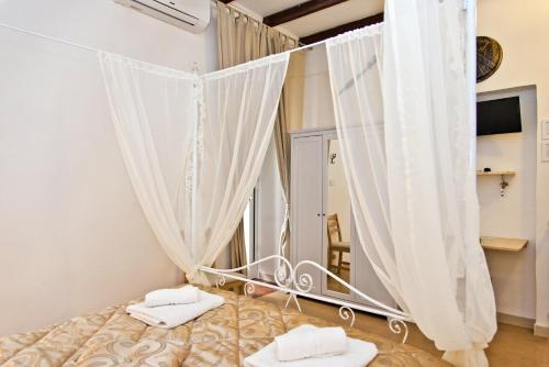1 dormitorio con 1 cama con cortinas y espejo en Sparta, en Taranto