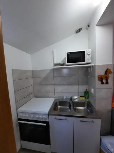 a small kitchen with a sink and a microwave at Apartment Blue Eyes in Podstrana