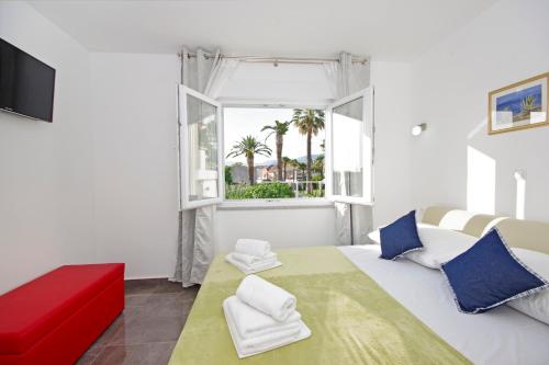 ein Schlafzimmer mit einem großen weißen Bett und einem Fenster in der Unterkunft Apartment Blue Eyes in Podstrana