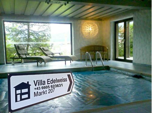 ein Schwimmbad mit einem Schild davor in der Unterkunft Villa Edelweiss - 3 to 6 Guests - private use of indoor pool, sauna and garden terrace in Abtenau