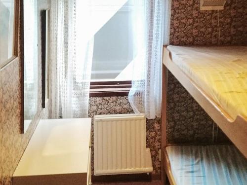 AxelsroにあるHoliday home HÖGKLINT IIIのベッドと窓が備わる小さな客室です。
