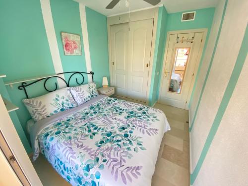 a bedroom with a bed with a purple and blue bedspread at Sea and mountain view Room with pool- Habitación PISO COMPARTIDO para 1 persona in Benalmádena