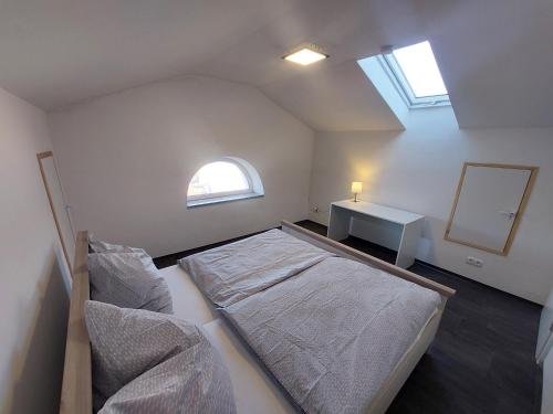 a bedroom with a bed and a desk and a window at Apartments im Mardefeldpalais in Ansbach